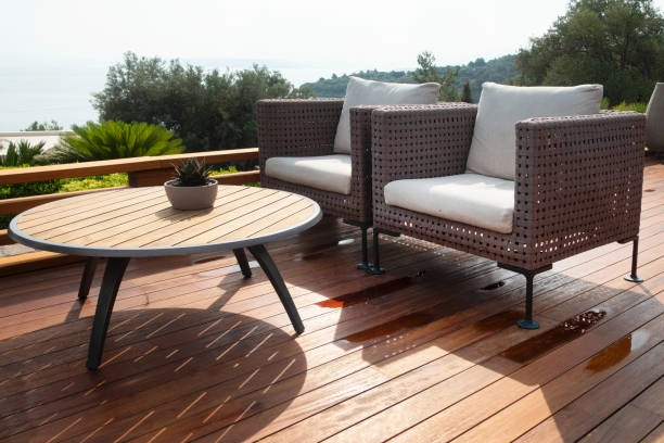 Stylish outdoor deck with modern wicker chairs and round table. -deck repair services