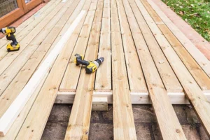 Wooden deck installation in progress with power drills and planks. -deck installation tools